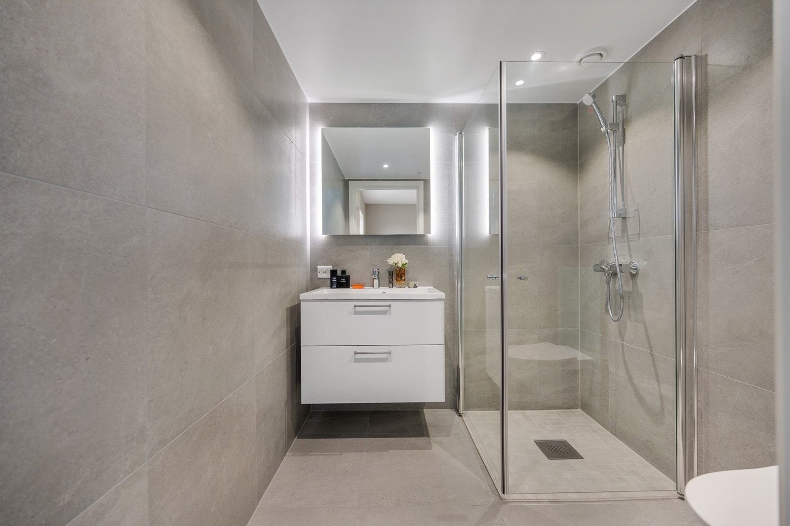 Nytt og fint bad med fliser på både vegger og gulv, noe som gir et rent og elegant uttrykk. Galleribilde