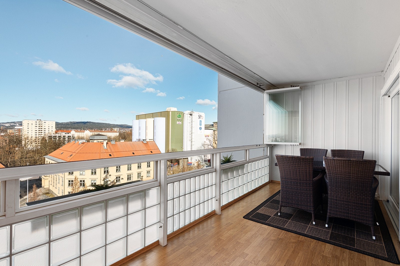 Innglasset balkong med gulv belagt med laminat. God plass til utemøbler Galleribilde