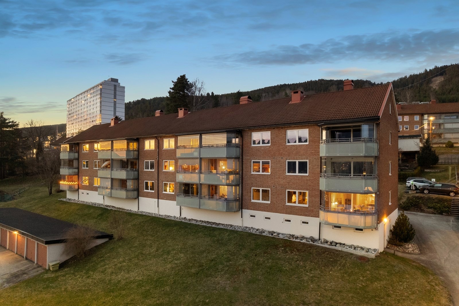 Borettslagets tomt er pent opparbeidet med grøntarealer, diverse beplantning og sittebenker Galleribilde