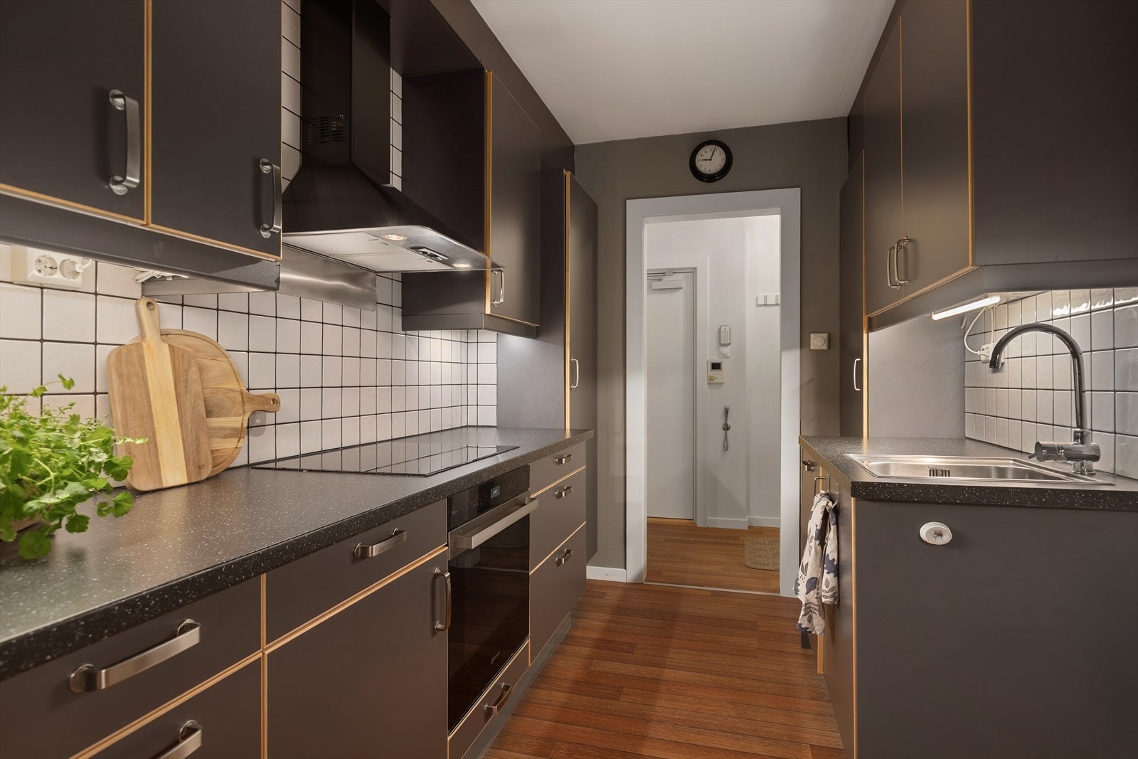 Det er fliser på vegg mellom over- og underskap og benkeplate er av laminat Galleribilde