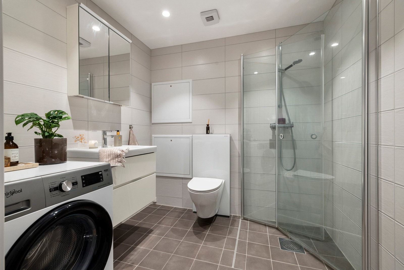 Delikat og pent flislagt bad med varme i gulv og opplegg for vaskemaskin. Galleribilde