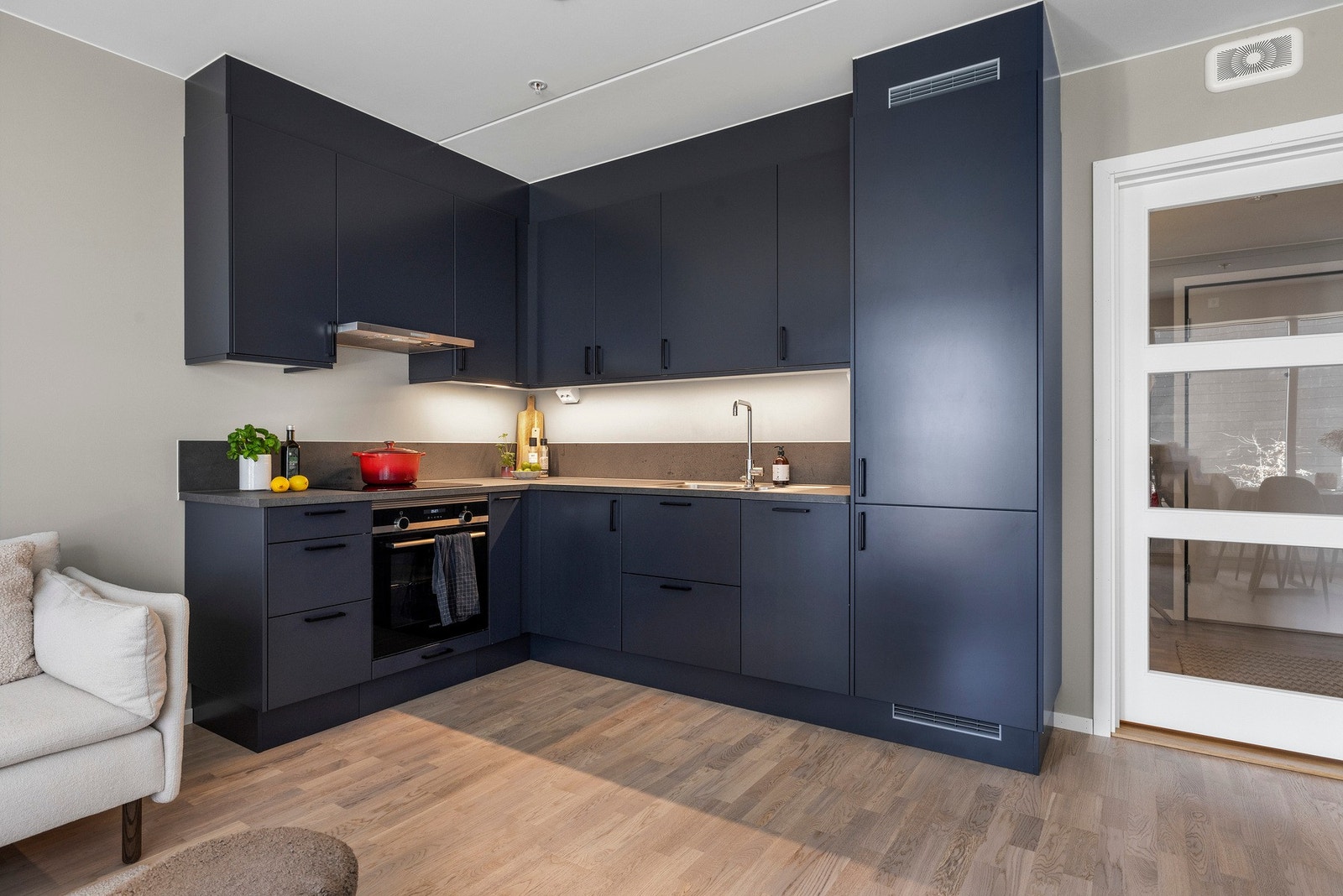 Lekkert kjøkken med integrert kjøl/fryseskap, oppvaskmaskin, stekeovn og induksjons platetopp Galleribilde