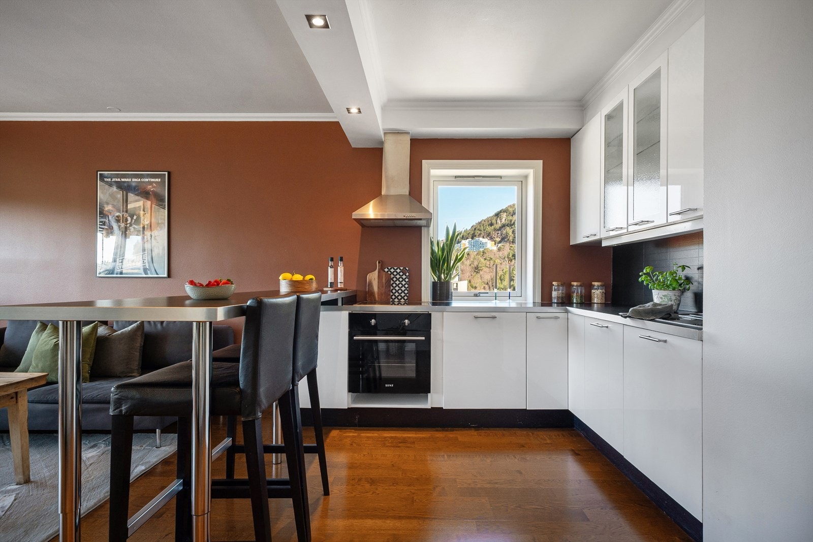 Flott kjøkken som er innredet med laminert benkeplate og hvite slette fronter. Spisebordet fungerer som et naturlig skille til stuen. Galleribilde