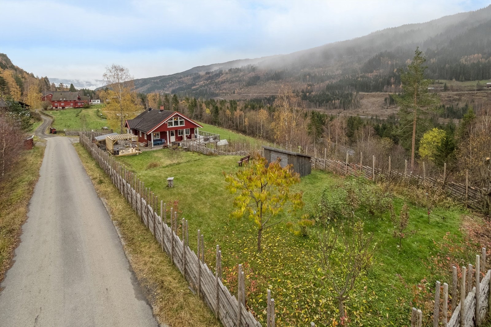 Opparbeidet tomt med plen, frukttrær og øvrig beplantning. Deler av tomten er inngjerdet med skigard. Galleribilde