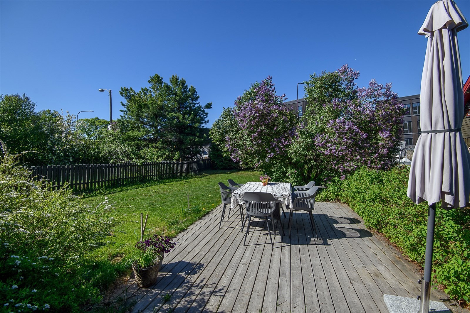 Pent opparbeidet hage med plenareal, beplantning og platting Galleribilde