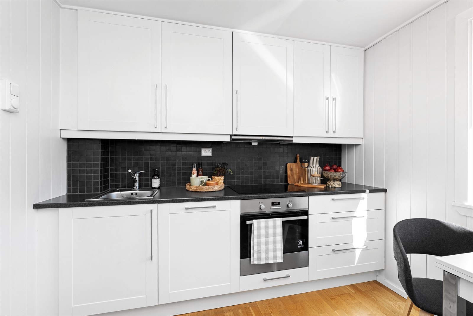 Kjøkkenet har tidsriktige lyse overflater, samt flislagt mellom over- og underskap. Innredningen inneholder alt du behøver som integrert oppvaskmaskin, stekeovn, platetopp, samt kjøleskap med frysedel. Galleribilde