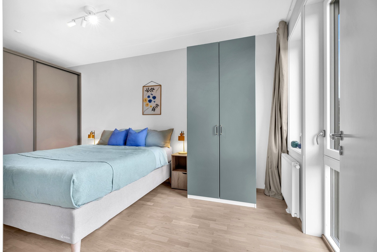 Leiligheten's hovedsoverom er luftig og lar seg enkelt møblere med seng, nattbord og garderobeløsning. Galleribilde