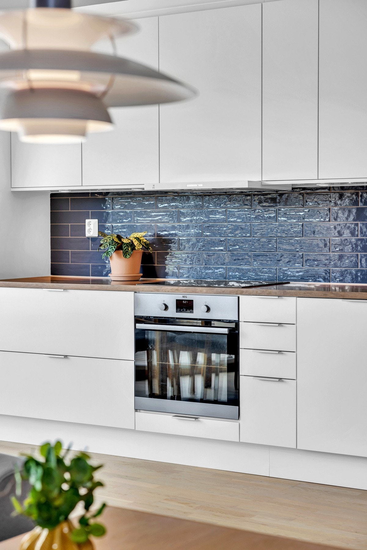 Kjøleskap med fryser, oppvaskmaskin, stekeovn og nedsenket induksjonstopp integrert i innredningen. Galleribilde