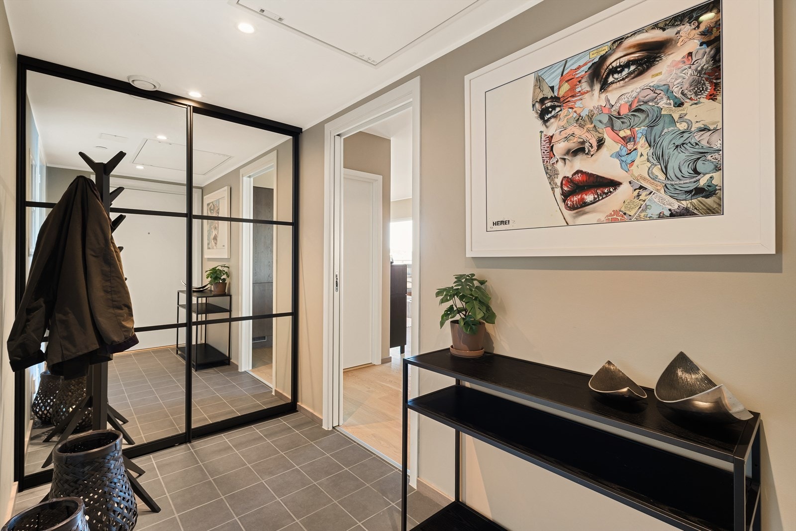 Entreen er praktisk flislagt og har en stor skyvedørsgarderobe med speildører. Galleribilde