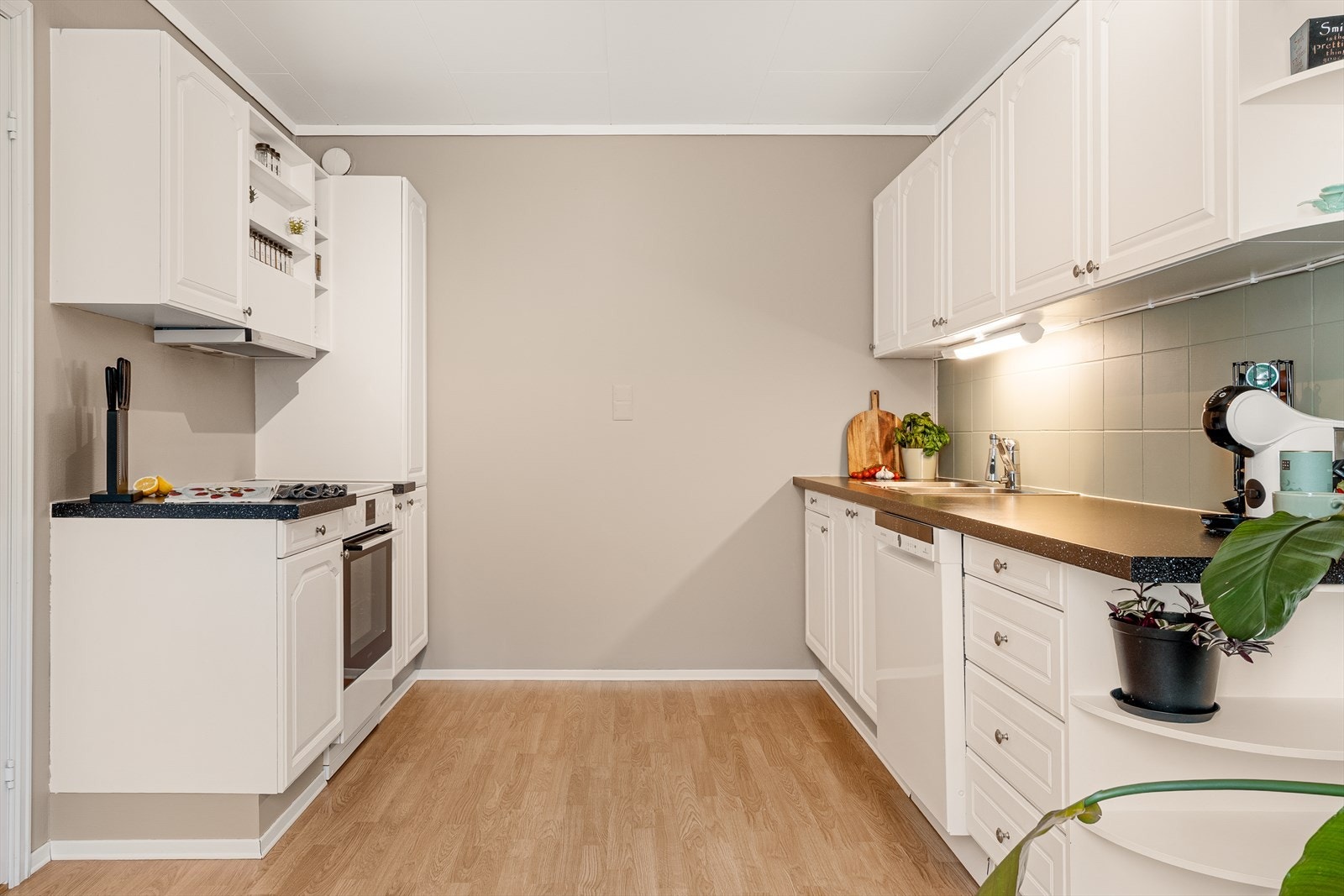 Vi trer inn i boligens flotte kjøkken med rikelig skap- og benkeplass Galleribilde