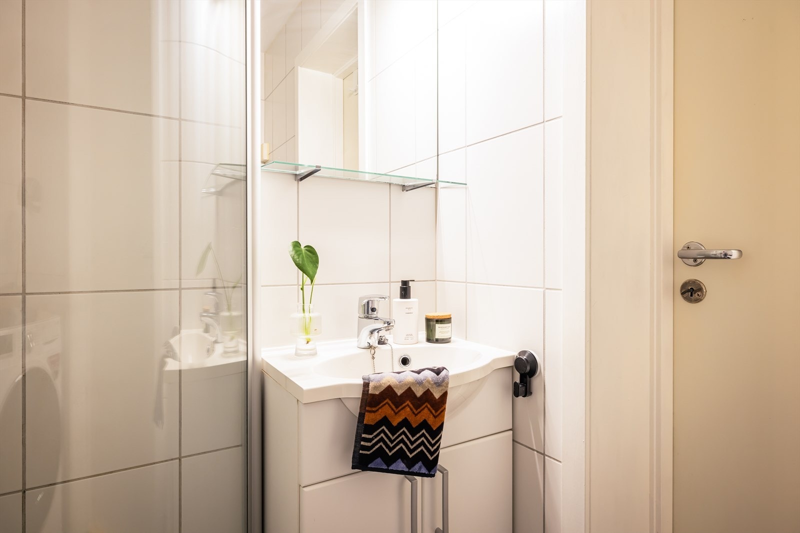 Badet er innredet med toalett, servant med møblement og dusj med foldedører som gjør badet mer plassbesparende. Galleribilde