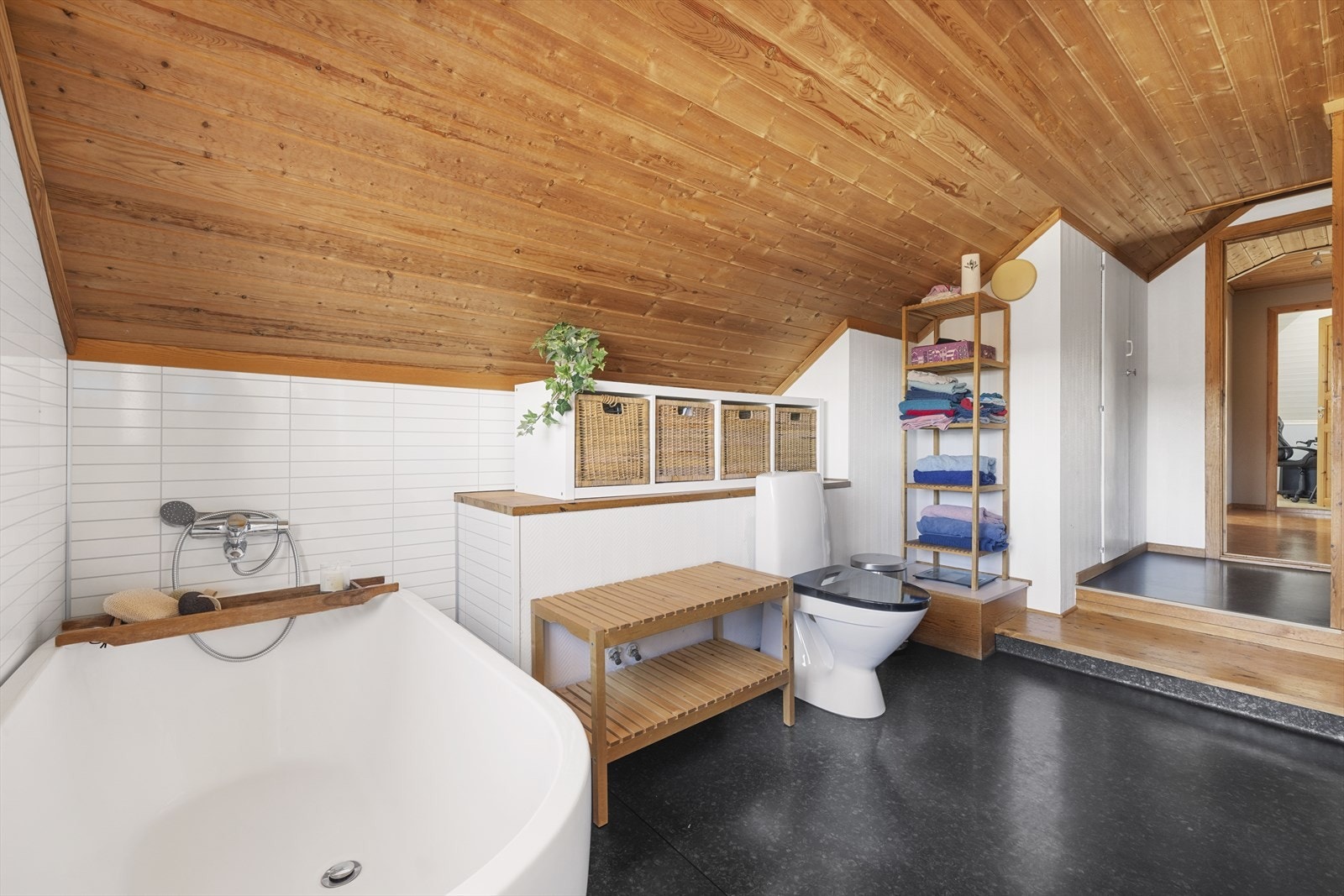 Badet har belegg på gulv med varmekabler, og baderomsplater og tapet på vegger Galleribilde