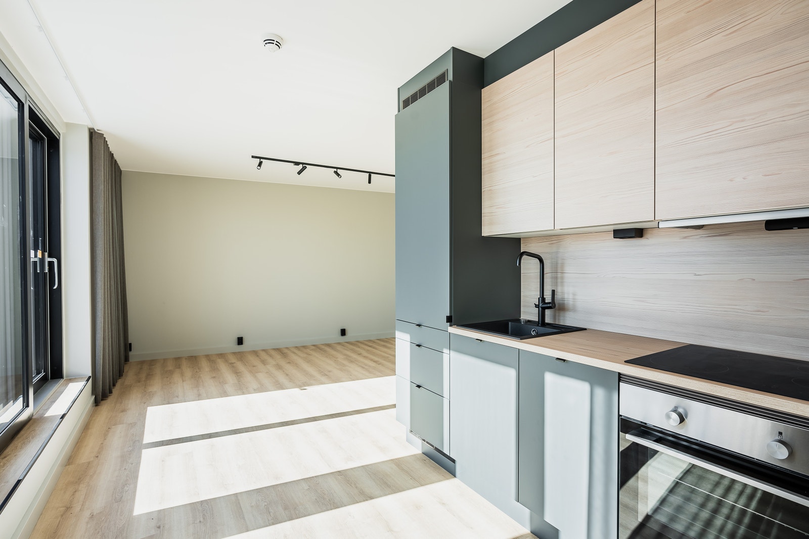 Tøft kjøkken fra HTH i modellen "Oslo". Overskap i lys ask-stil og underskap i fargen base grønn. Bilde fra en tilsvarende leilighet. Galleribilde