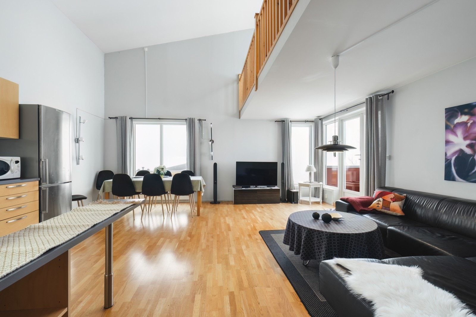 Åpen stue og kjøkken med store vinduer som slipper inn naturlig lys som er med på å skape en god romfølelse og atmosfære. Galleribilde