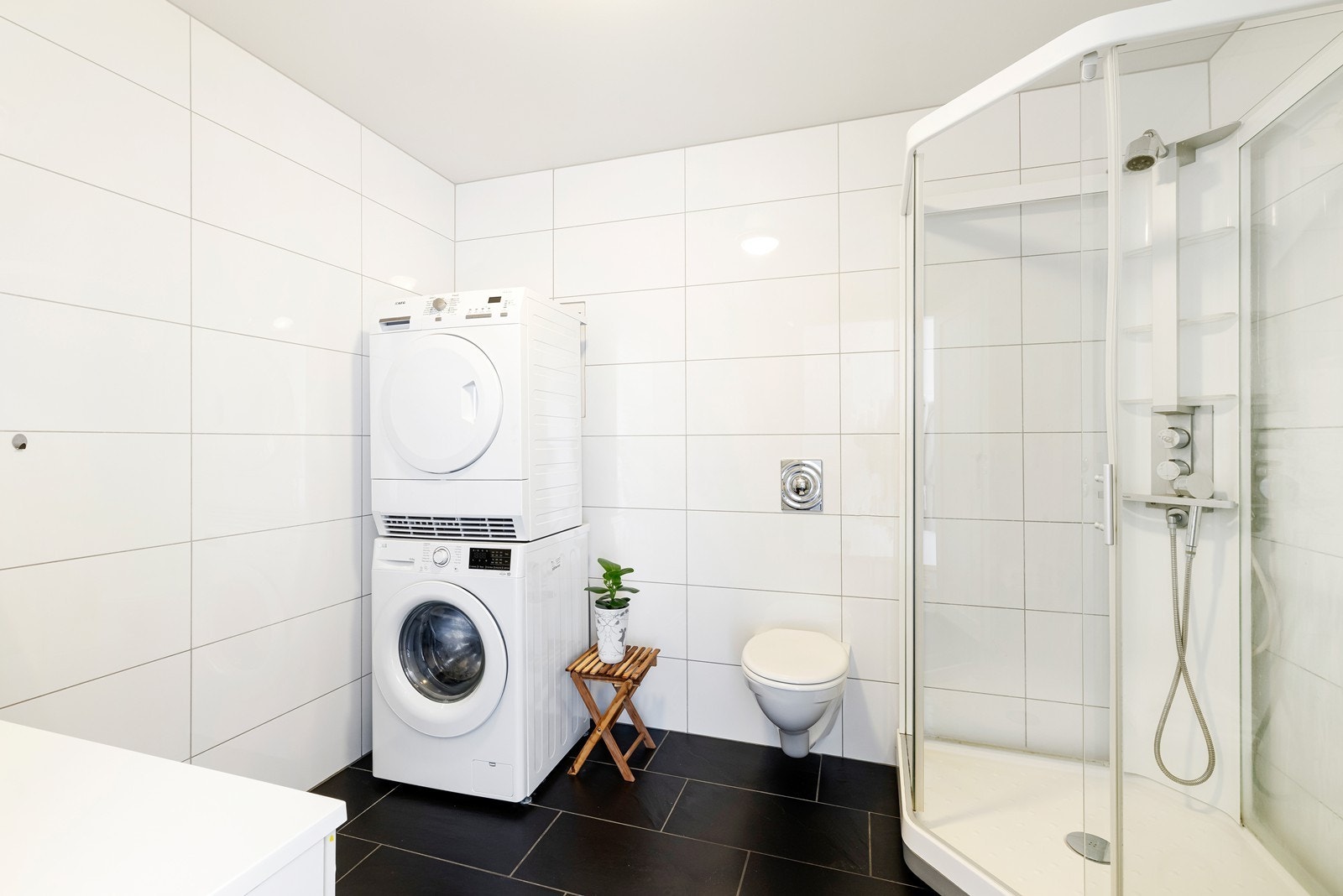 Bad inneholder vegghengt wc, servant, dusjkabinett og opplegg for vaskemaskin Galleribilde