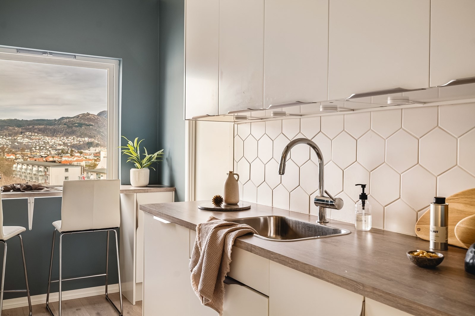 Det er lagt fliser over benkeplate og belysning under overskap Galleribilde