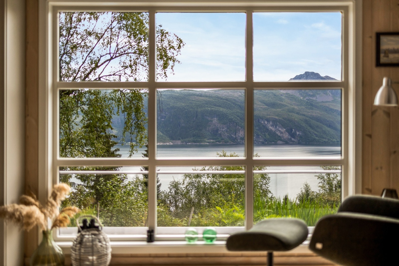 De store vinduene rammer elegant inn den vakre utsikten, og godstolen er strategisk plassert, klar for å bli din nye favorittplass. Galleribilde