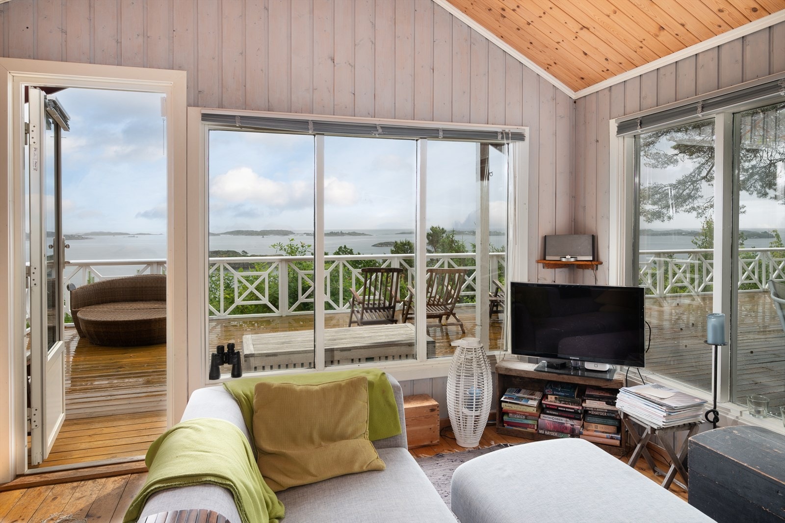 Lys stue med store vindusflater og utgang til stor terrasse med flott utsikt Galleribilde