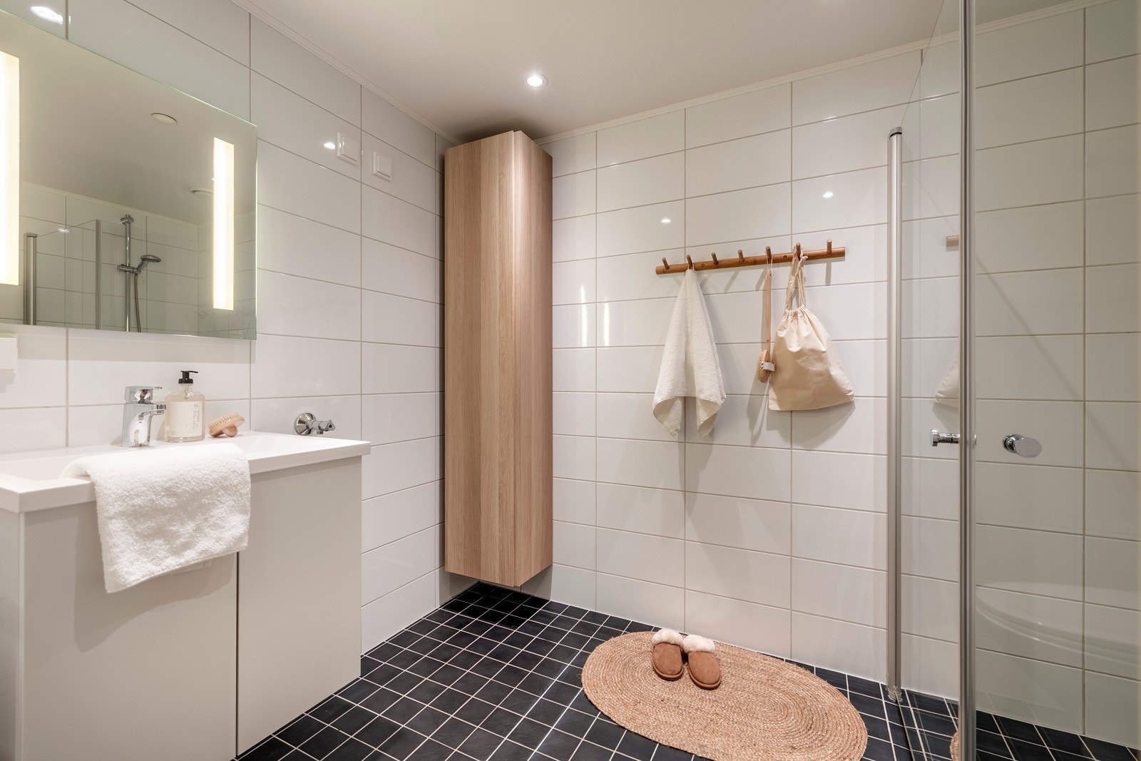 Badet har et stilrent uttrykk med flislagte vegger og gulv, malt slet himling med innfelt downlights og gulvvarme. Galleribilde