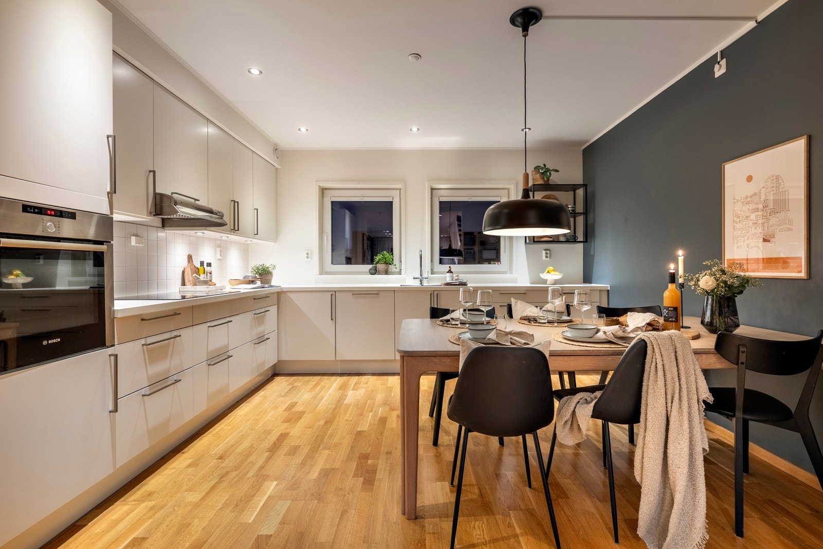 Stilren og moderne kjøkkeninnredning fra HTH med hvite slette fronter og laminerte benkeplater med nedfelt oppvaskkum. Galleribilde