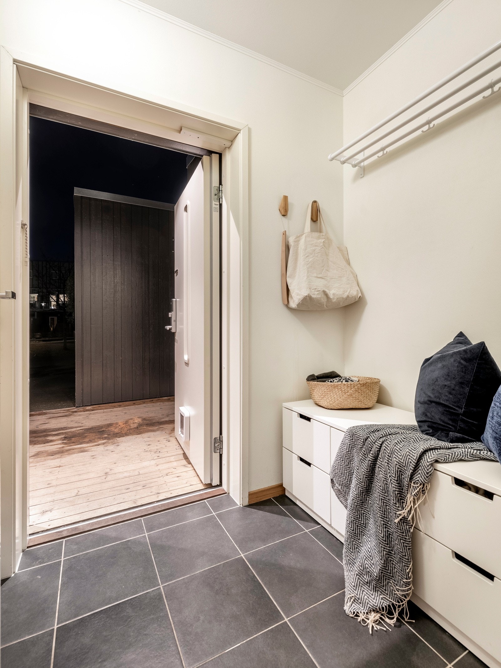 Vel innenfor døren ønskes du velkommen av et lyst og stilrent entréområde med flislagt gulv og vegger malt i lyse fargetoner. Galleribilde