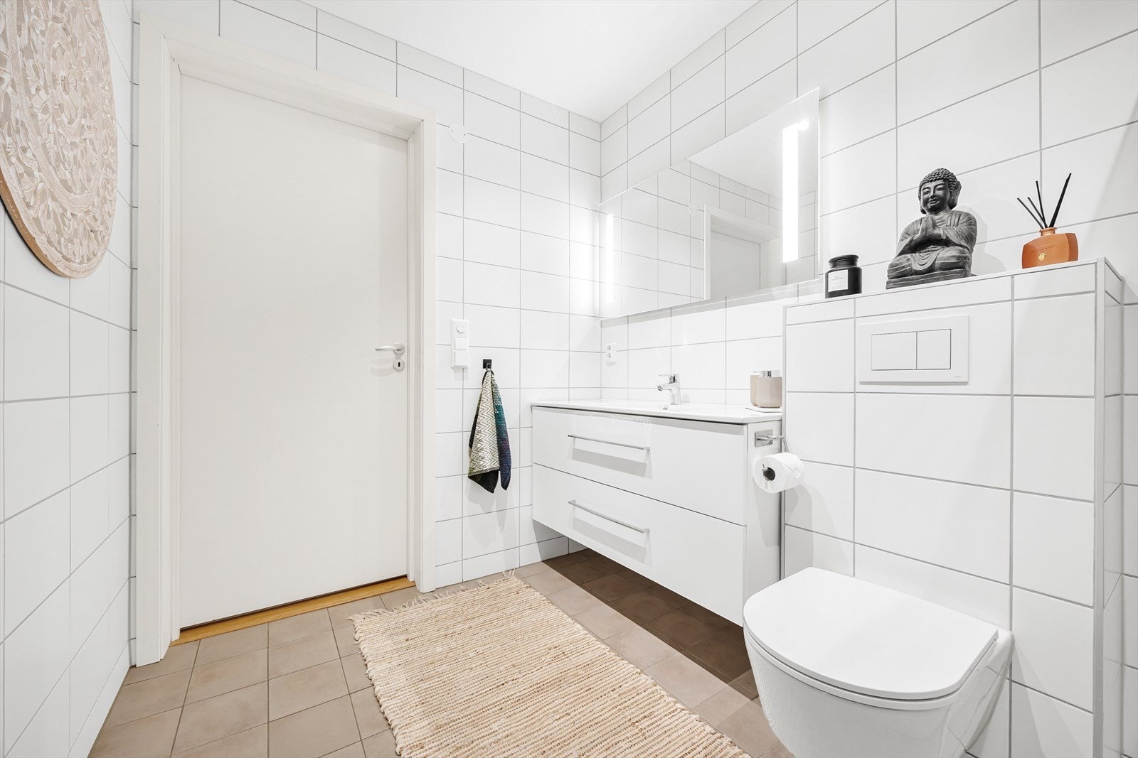 Boligen byr på et stilrent bad med fliser på gulv og vegger. Galleribilde