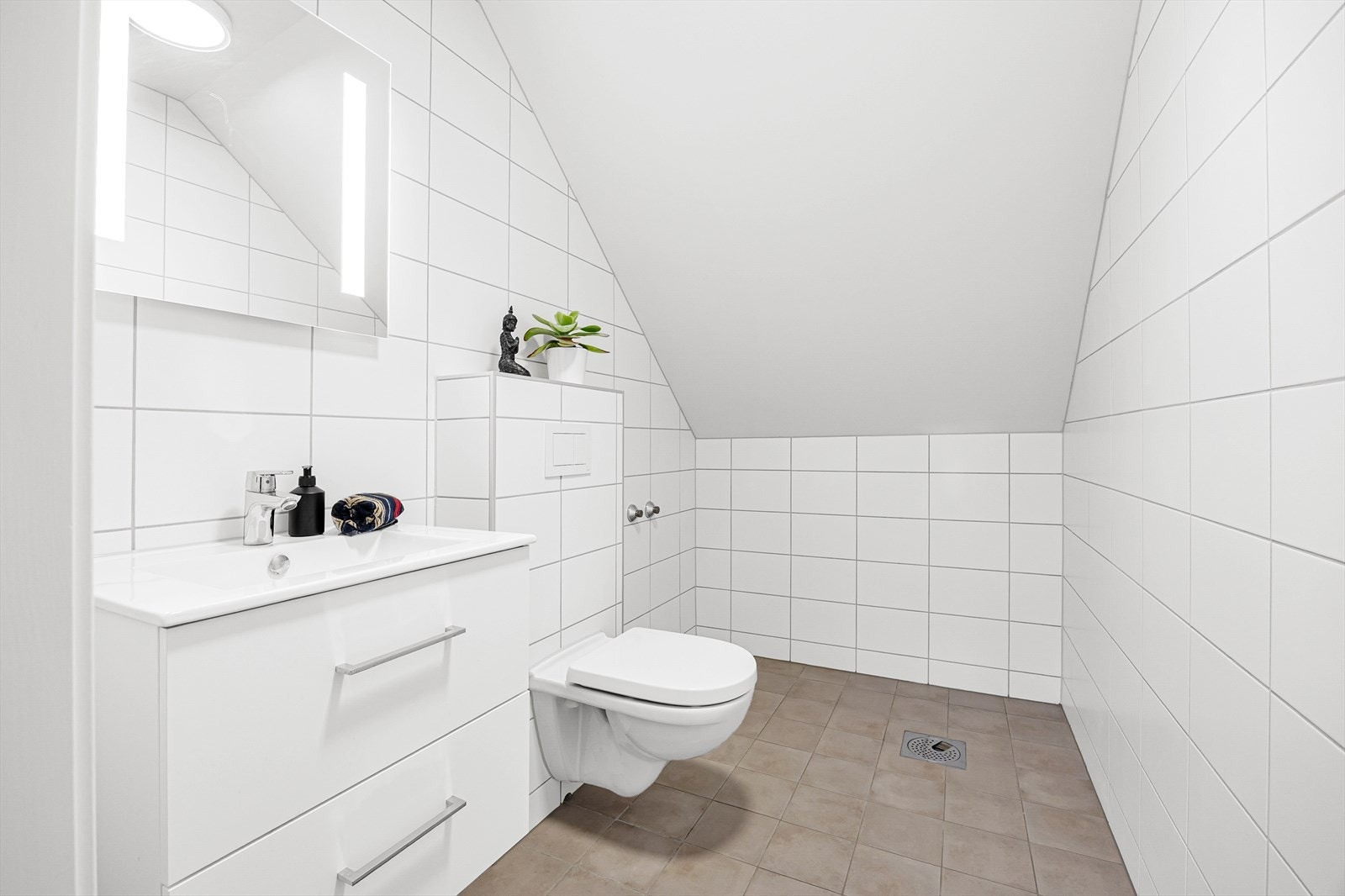 Badet har innredning med lagringsplass og vegghengt wc. Det er opplegg til badekar innerst i rommet. Galleribilde