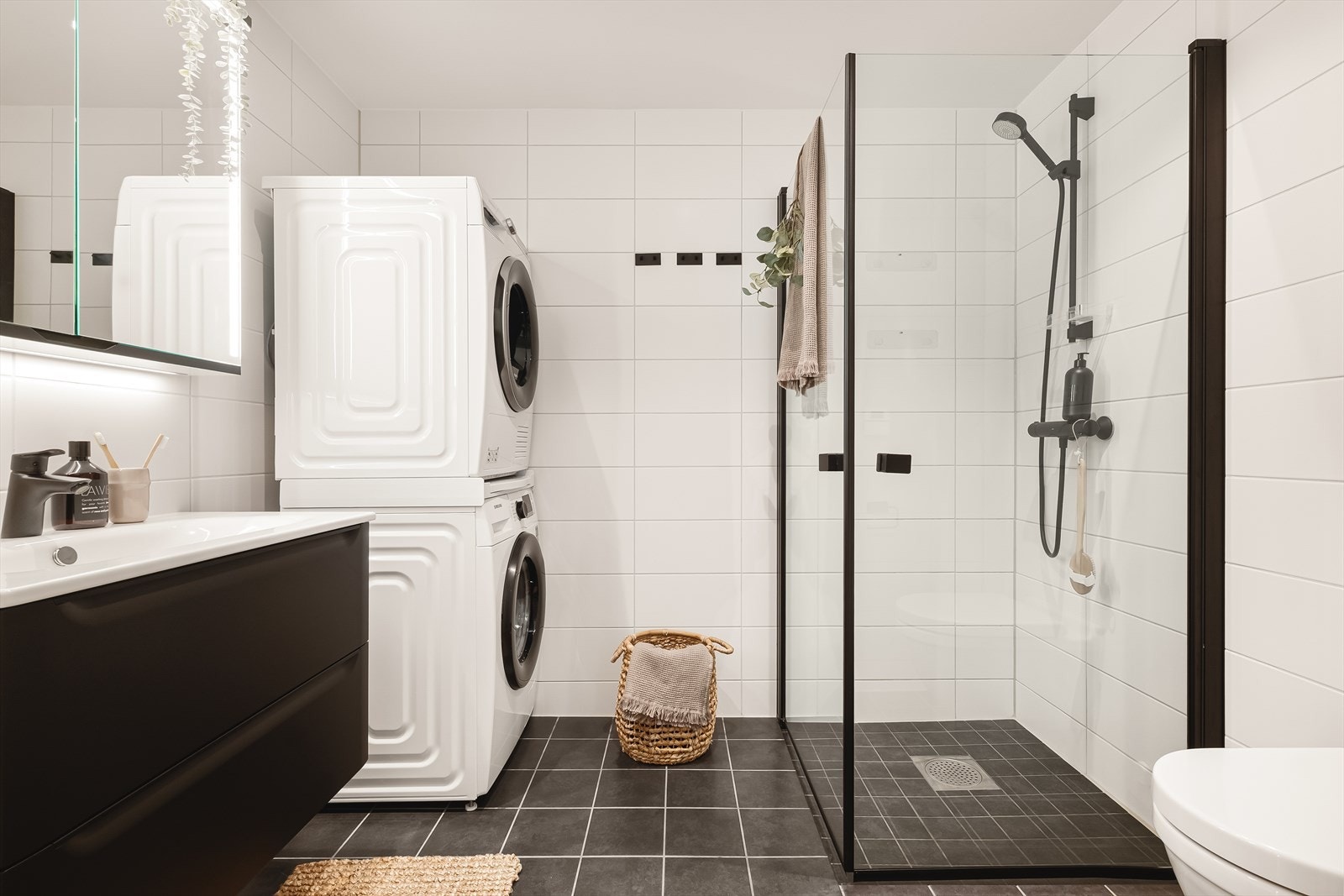 Badet er påkostet med Linnbad Mari 80cm møbel, ask porselen servant og 2 stykk sorte håndtak | Videre er det en Oraas Apollo Dusjsett i matt sort | Dusjdørene er fra Pyxis med svart matt profil Galleribilde