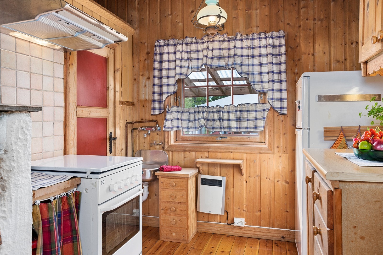 Fra stua er det åpent inn til et enkelt kjøkken, hvor innredningen har fronter i heltre furu. Galleribilde