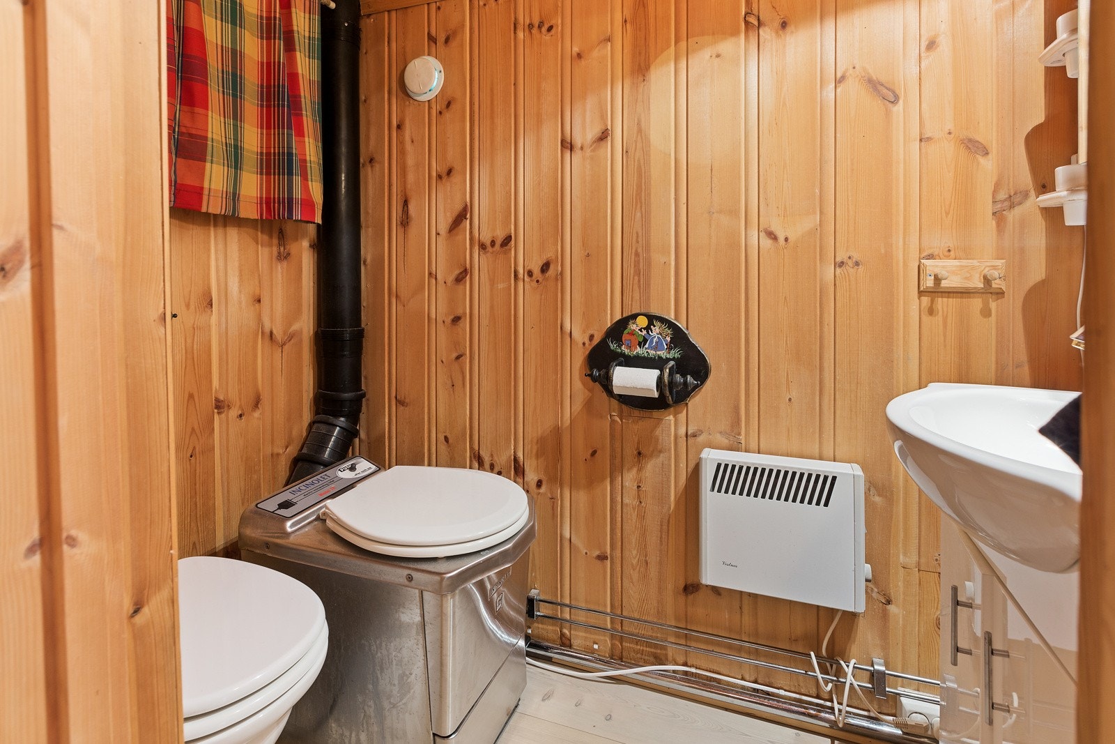 Inne i hytta er det toalettrom med servantskap, forbrenningstoalett og urinal. Galleribilde