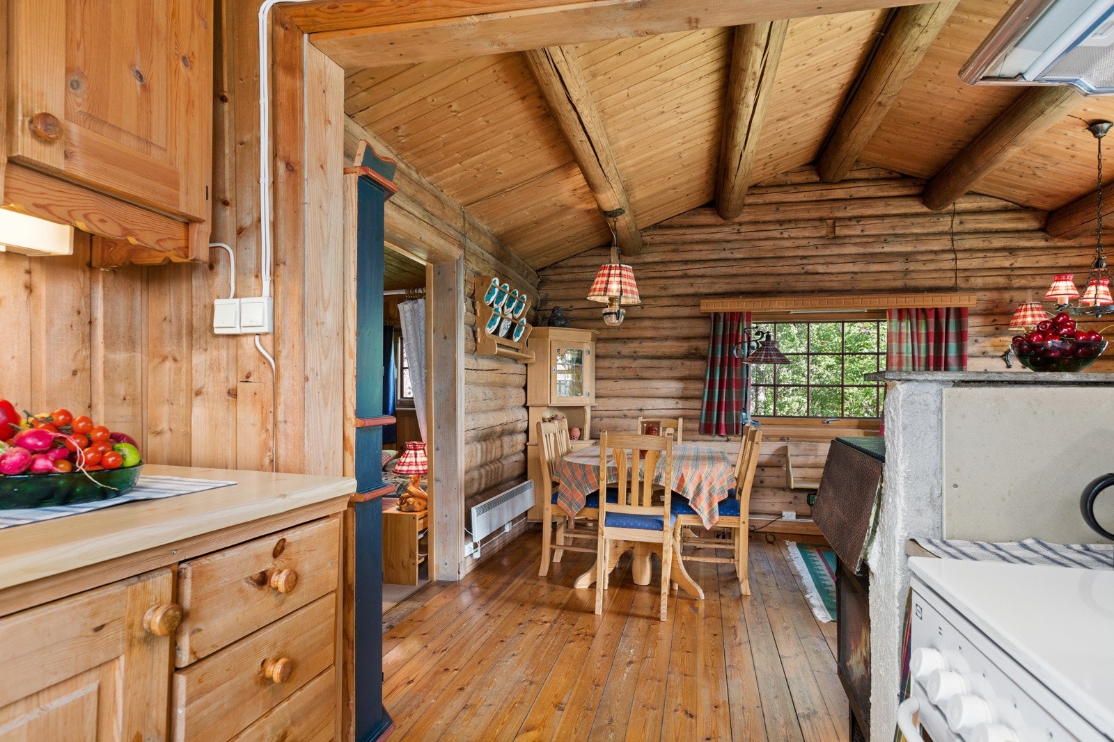 Fra stua er det åpent inn til et enkelt kjøkken, hvor innredningen har fronter i heltre furu. Galleribilde