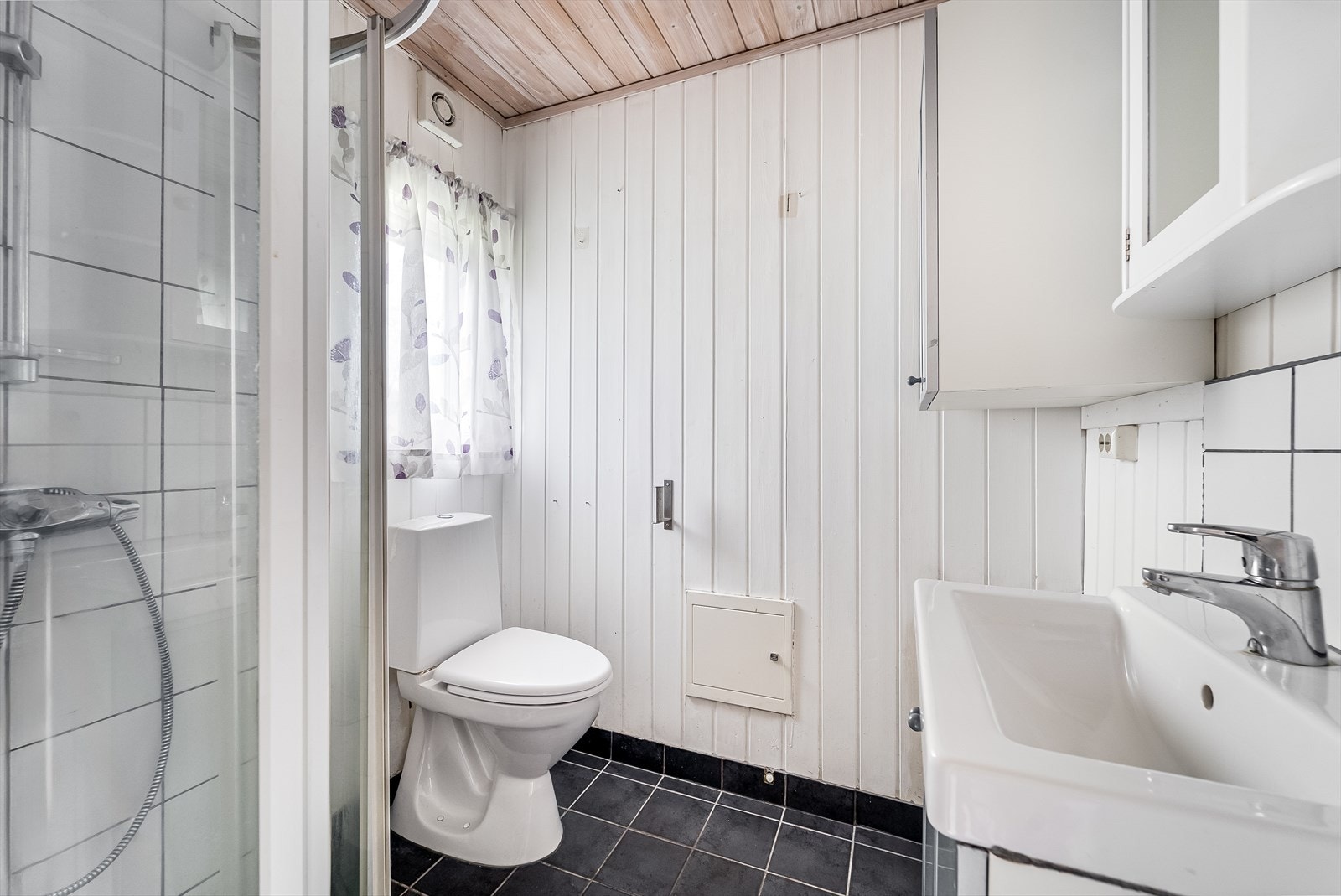 Bad med innredning, toalett og dusjløsning. Galleribilde