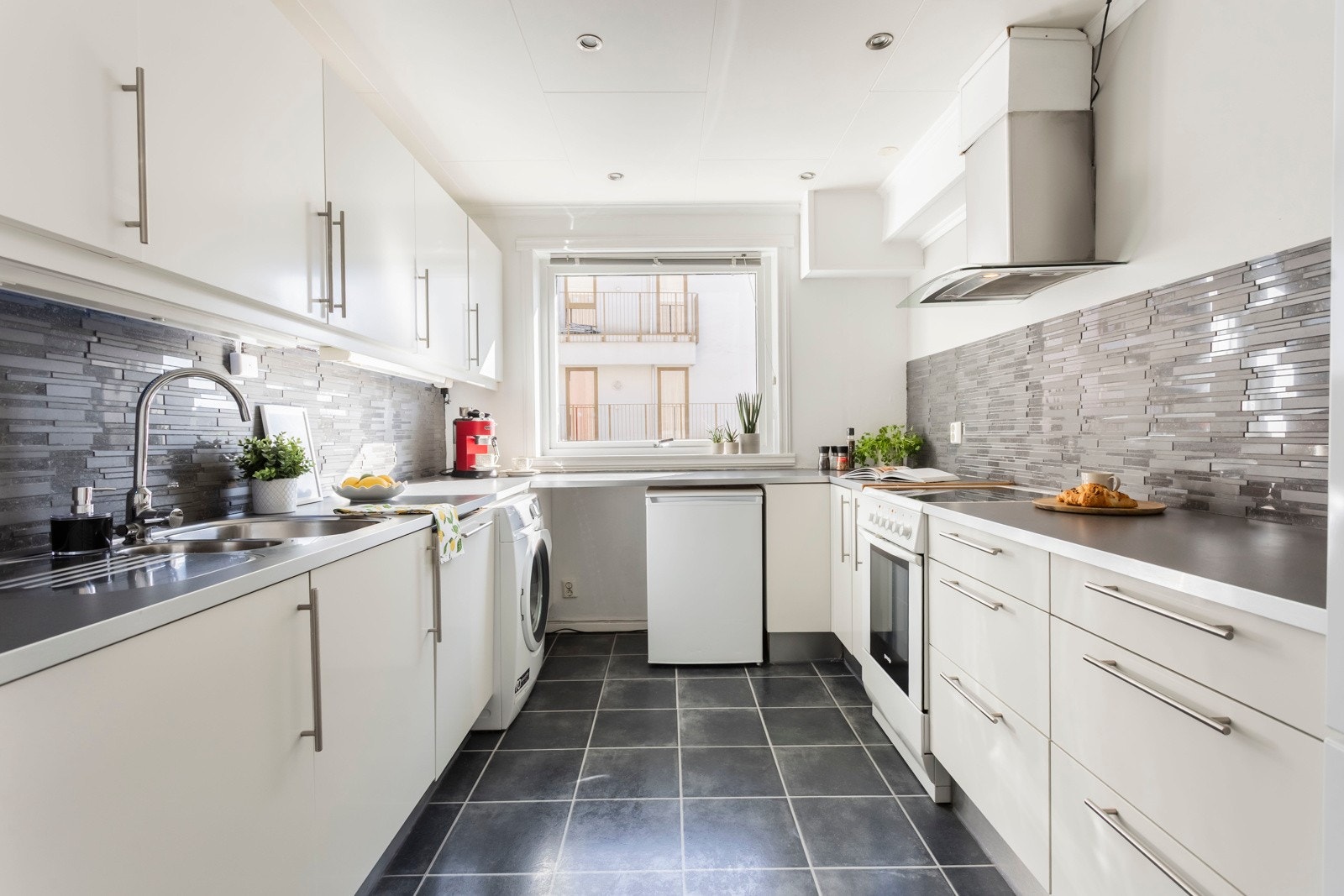 Kjøkkeninnredning fra IKEA har en tidløs fremtoning med lyse glatte fronter og en mørkere benkeplate i fin kontrast. Galleribilde