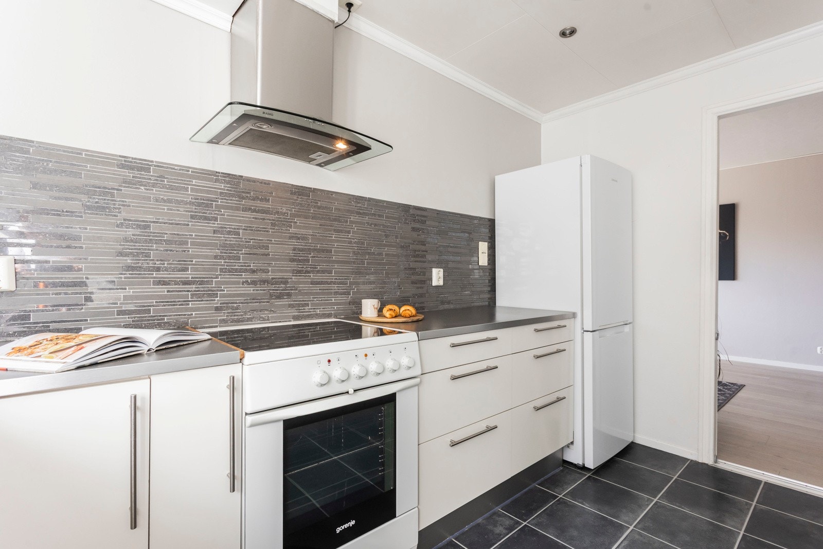 Kjøkkenet er utstyrt med oppvaskmaskin, komfyr og frittstående kjøleskap. I tillegg er det opplegg for vaskemaskin og plass til fryseskap. Galleribilde