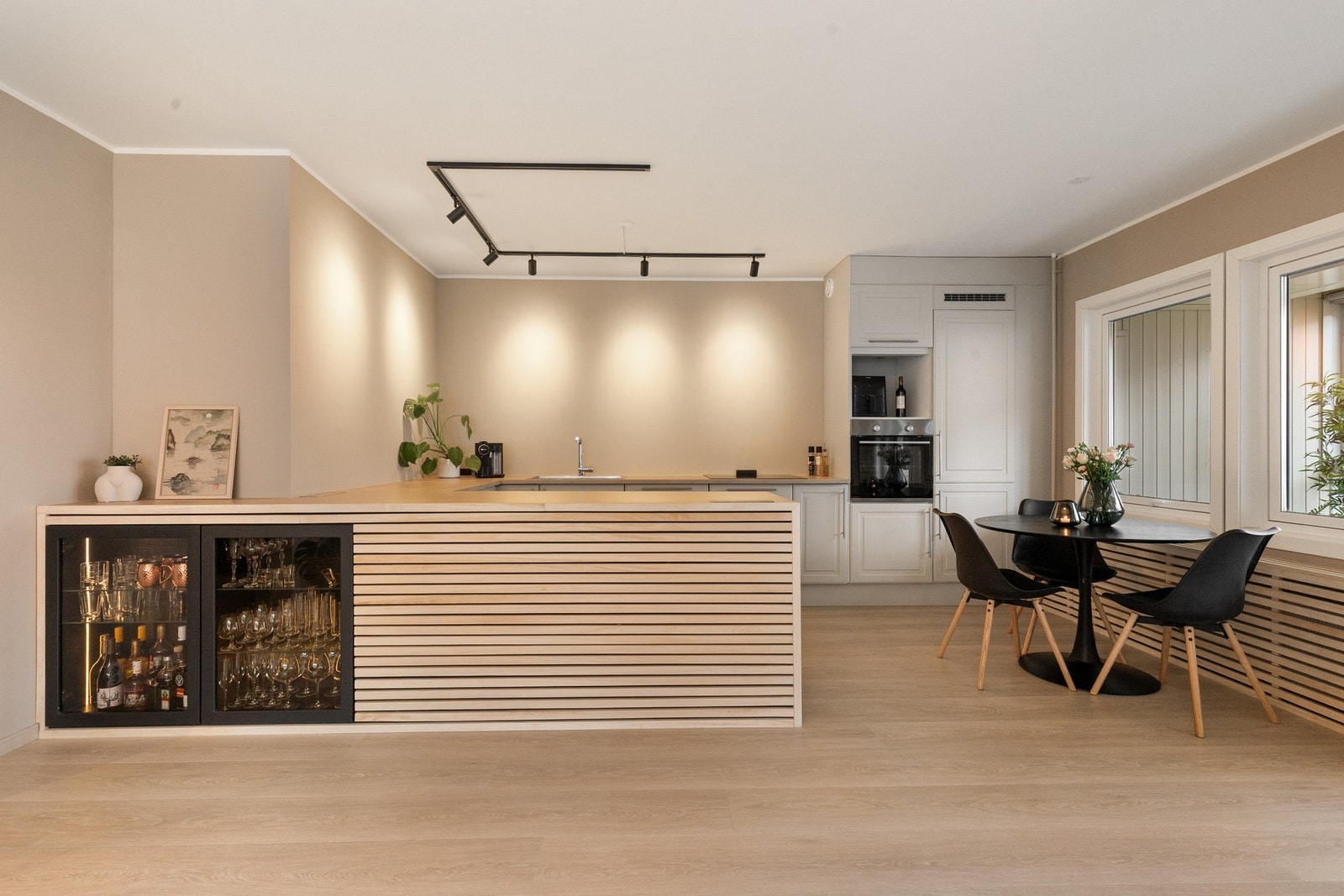 Plassbygd preg og smarte løsninger - dette kjøkkenet er laget for å brukes, og for å se bra ut. Legg merke til den elegante bruken av moderne spiler som er gjennomgående i hele leiligheten. Galleribilde