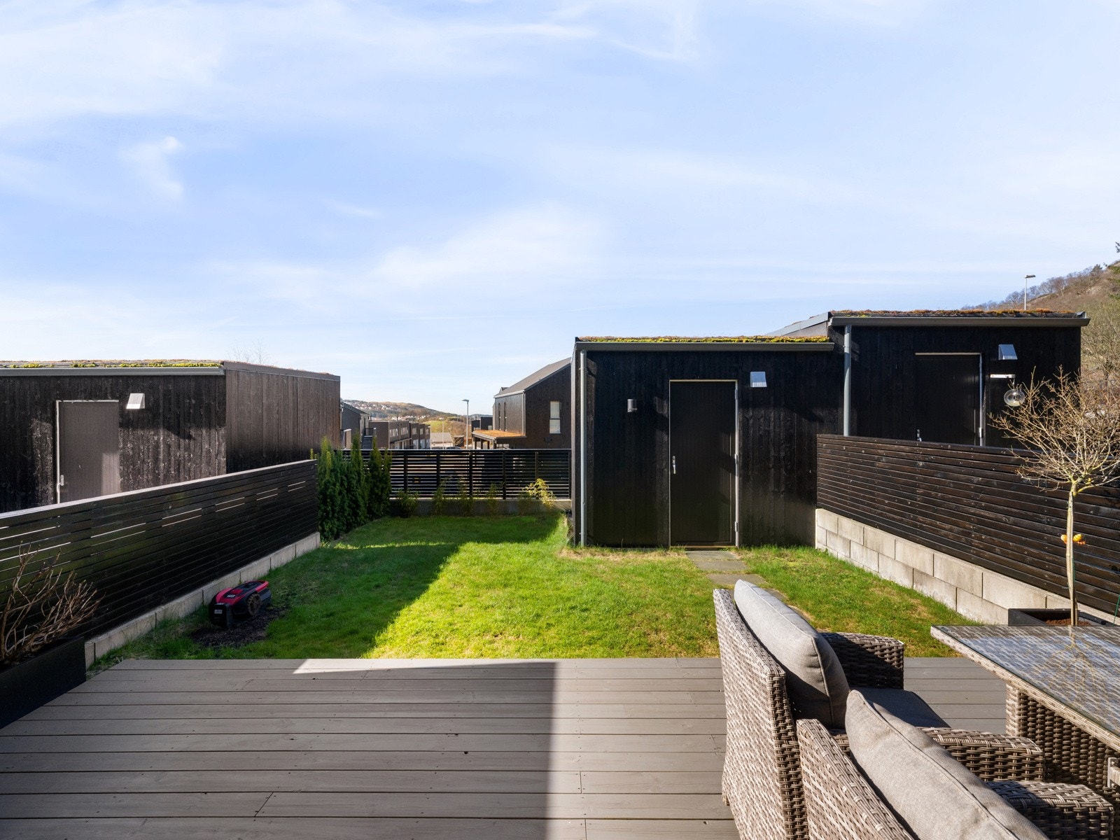 Fra stuen er det utgang til solrik terrasse, hage med plen og bod Galleribilde