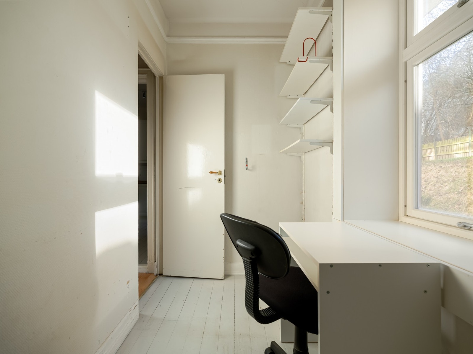 Det er innredet med praktisk hylleløsning og kontorpult. Det må også nevnes at det er deilig å ha utsikt til bakgård når man jobber! Galleribilde