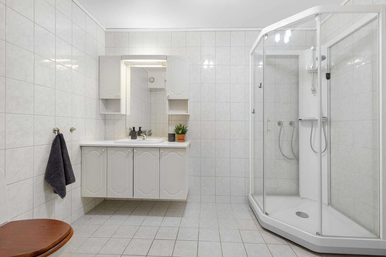 Helfliset baderom med praktiske løsninger og komfortabel gulvvarme. Galleribilde