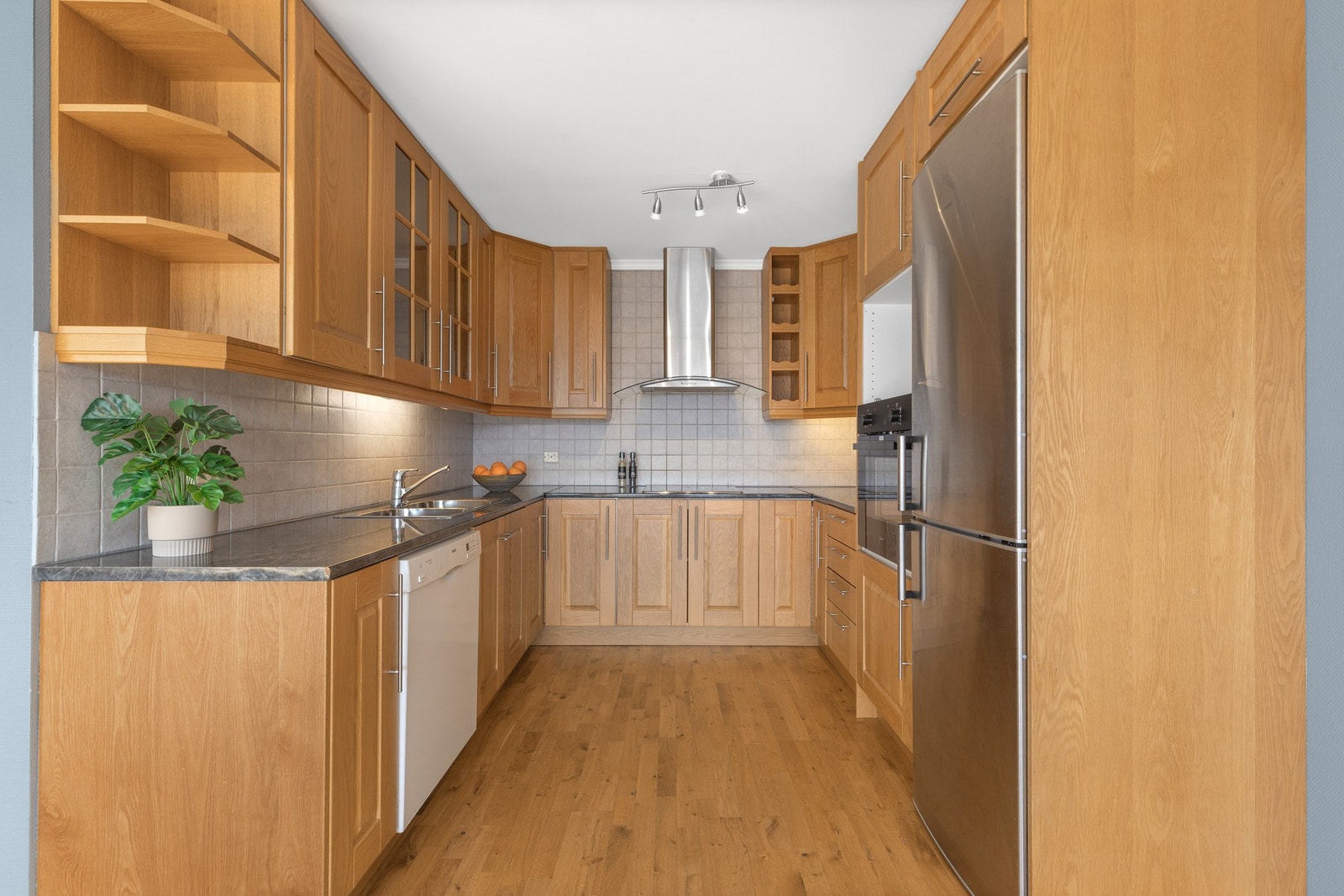 Kjøkken med gjennomtenkte detaljer som belysning under overskap og god plass til oppbevaring. Galleribilde