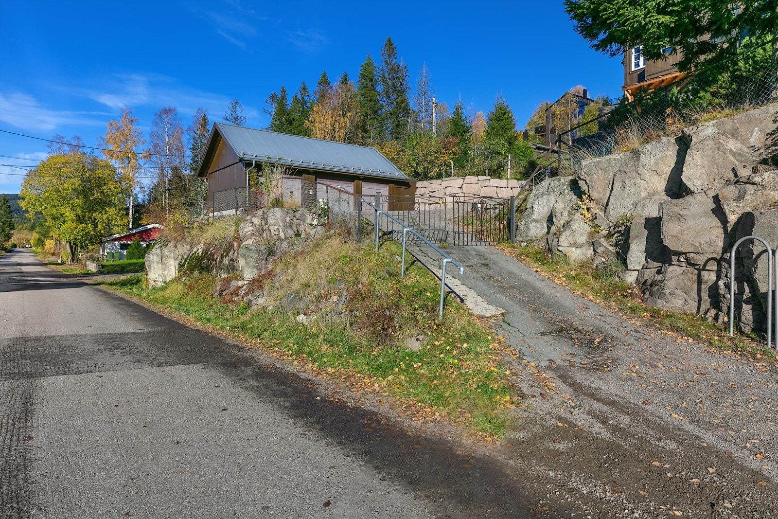 Tomten er inngjerdet med port mot veien, og deler av eiendommen er naturtomt med blåbærlyng, skogblomster og annen stedlig vegetasjon. Galleribilde