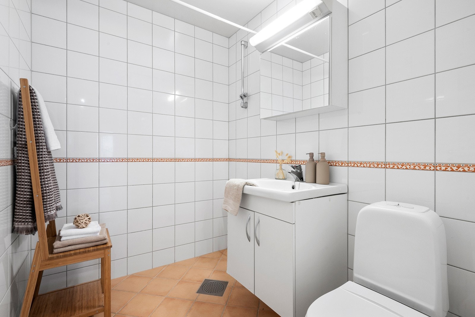 Bad 1, flislagt bad med gulvvarme, dusjplass, servant med underskap, speilskap med lys over og wc. Galleribilde