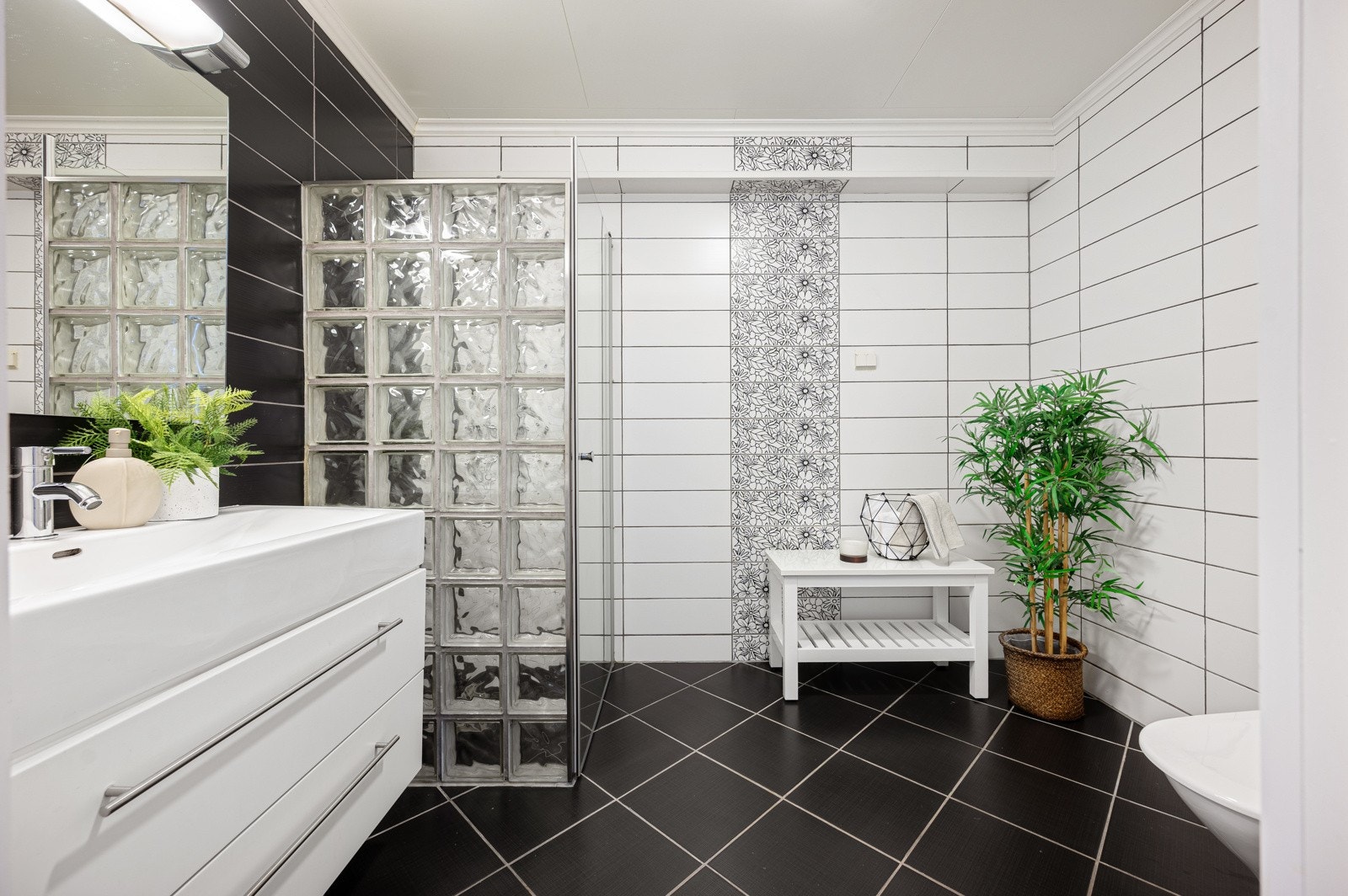 Badet er av god størrelse og inneholder vegghengt servantinnredning, speil med overlys, dusjnisje med glassvegg og dør samt gulvstående toalett. Galleribilde