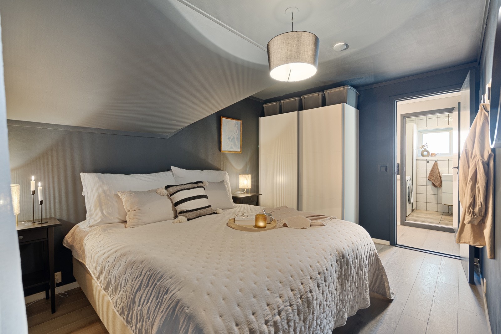 Både vegger og tak er malt i en dempet blåtone, og det er montert en skyvedørsgarderobe langs innerste vegg. Galleribilde