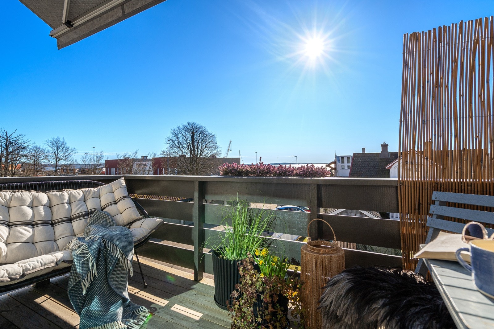 Balkongen har dekke av terrassebord, rekkverk i tre, skjermende markise, og en størrelse på ca. 5 kvm som gir plass til komfortable utemøbler. Galleribilde