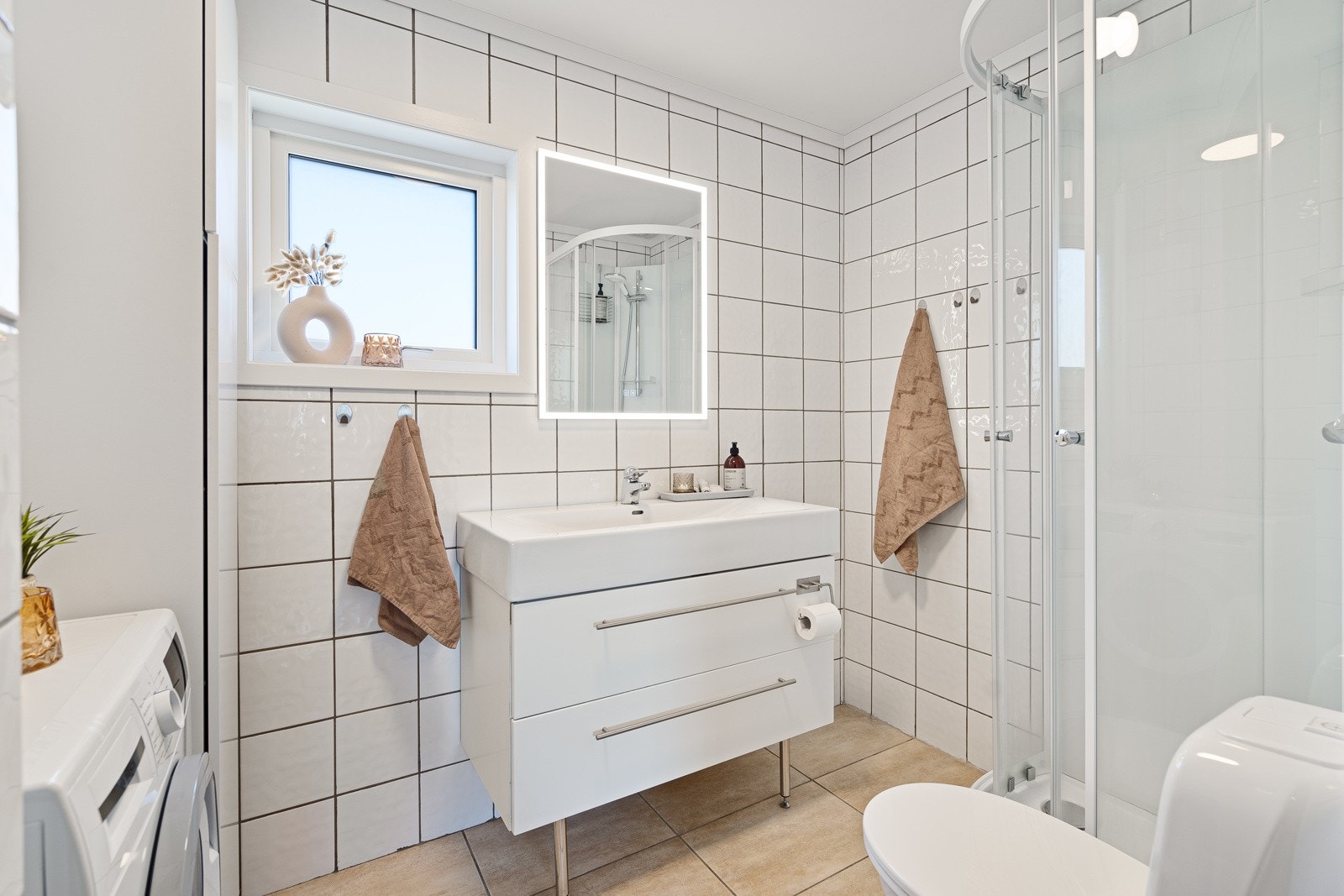 Badet ble pusset opp i 2006 og har varmekabler i gulvet. Innredningen består av en heldekkende servant på hvit skuffeseksjon, matchende høyskap, speil med rammebelysning, et toalett fra 2013 og et dusjkabinett. Galleribilde