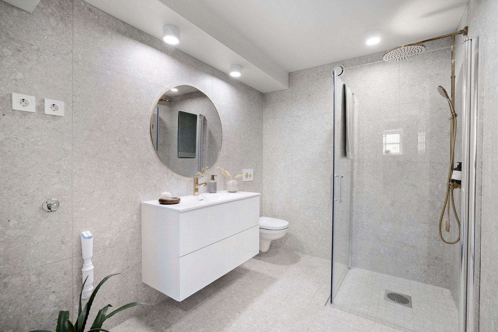 Badet er lyst og tiltalende med terrazzo fliser på gulv og vegger, gulvvarme og downlights. Galleribilde