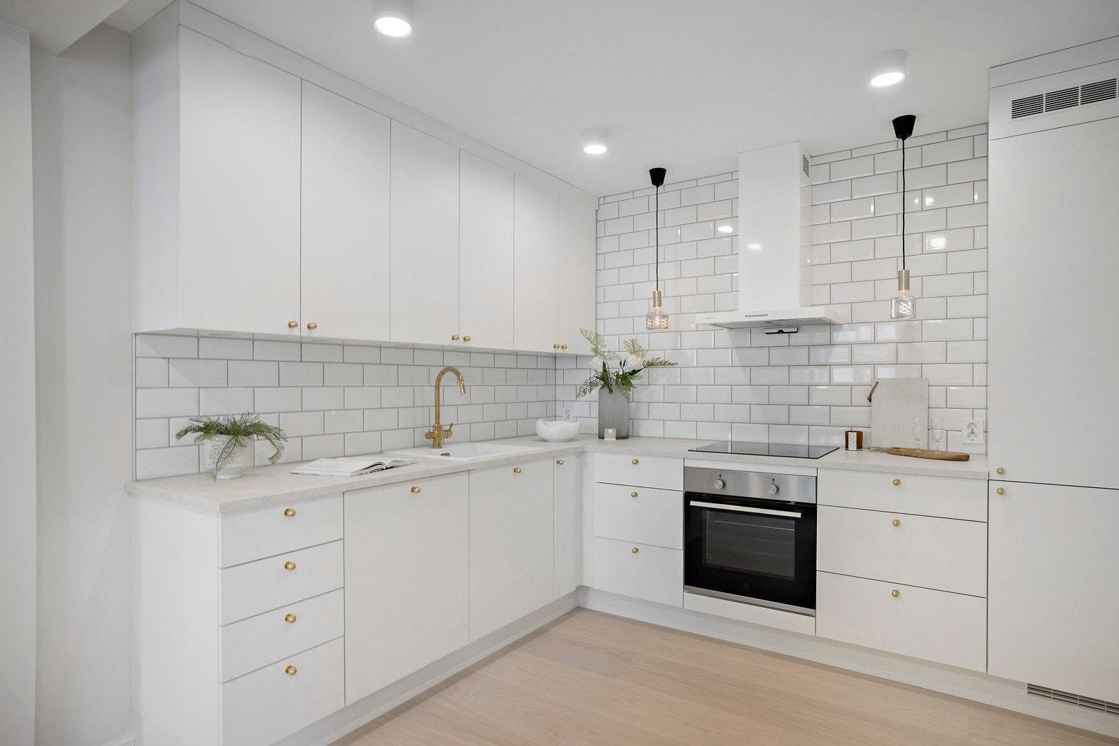 Kjøkkenet har kran, håndtak og pendellamper i messing, som gir det hele et eksklusivt uttrykk. Galleribilde