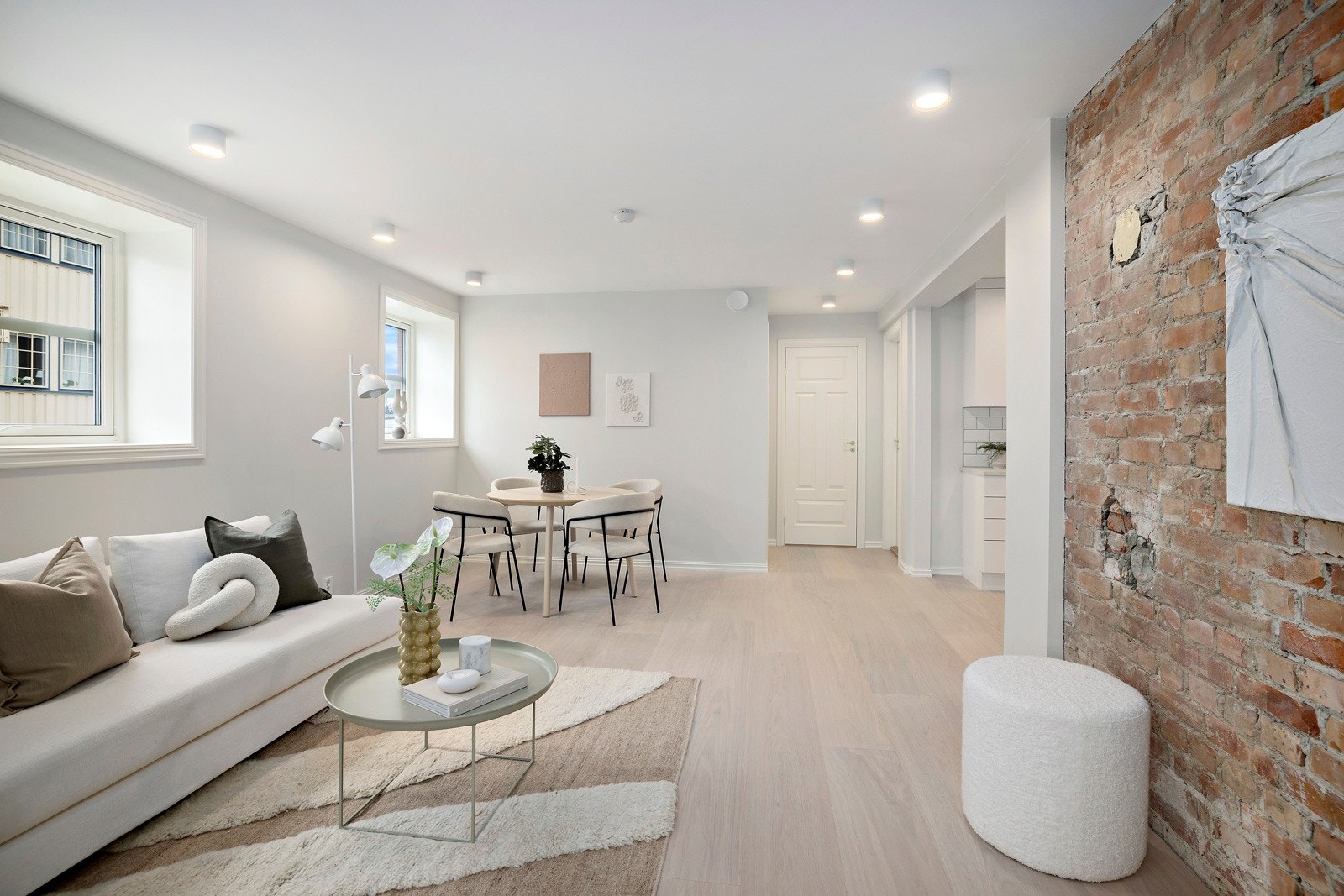 En vegg i naken tegl bryter fint opp mot de lyse, glatte overflatene og gir rommet et autentisk særpreg. Galleribilde