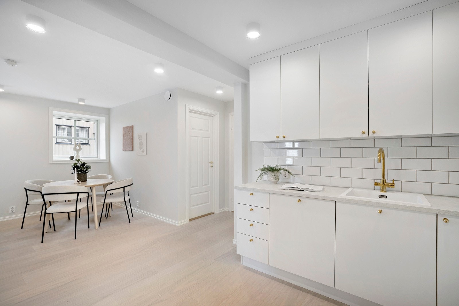 Kjøkkenet har en lys arbeidssone med pendellamper, benkebelysning under skap og downlights i taket. Galleribilde