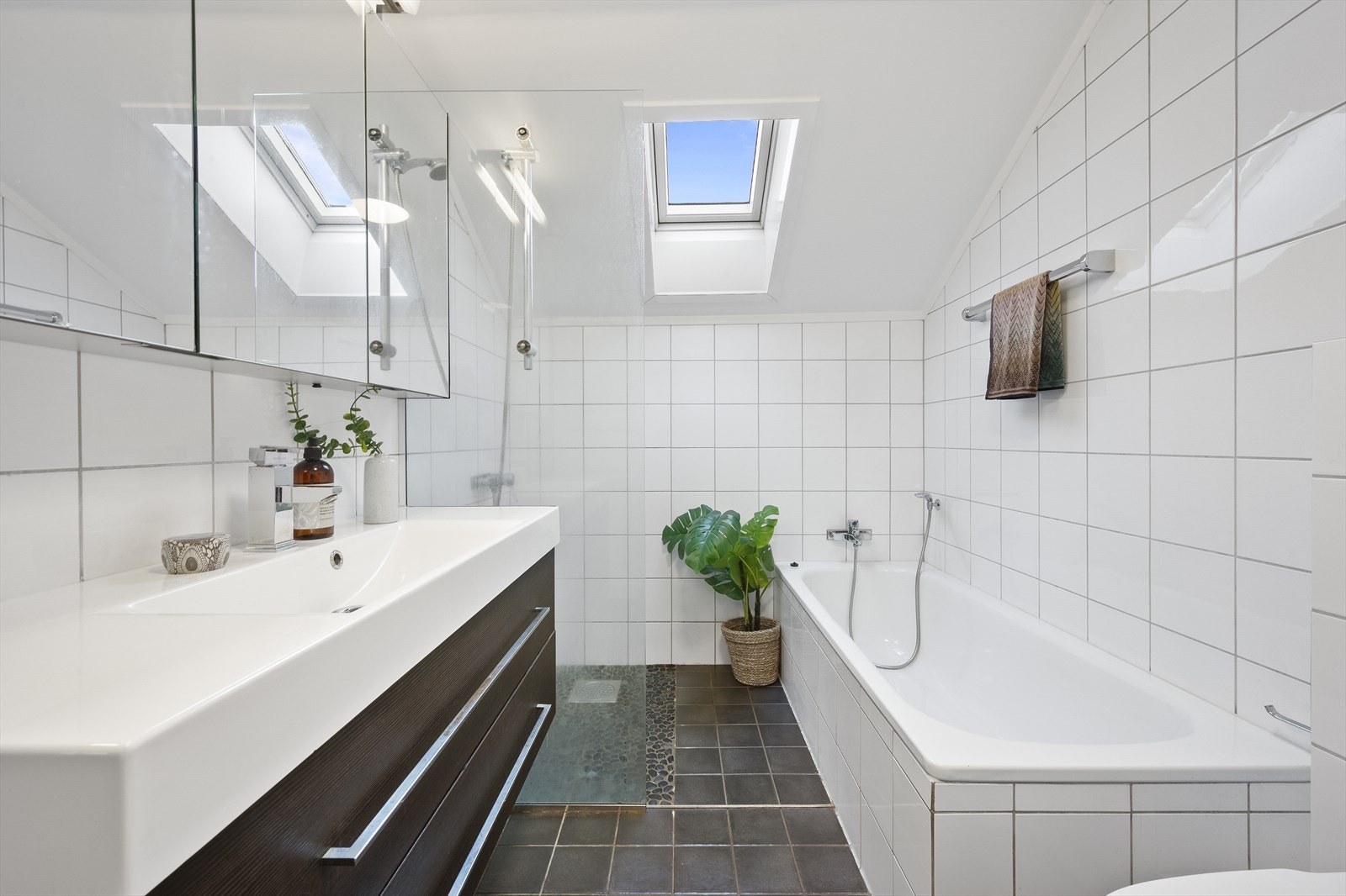 Funksjonelt og tidløst bad fra 2014 med flislagte overflater og elektrisk gulvvarme. Galleribilde